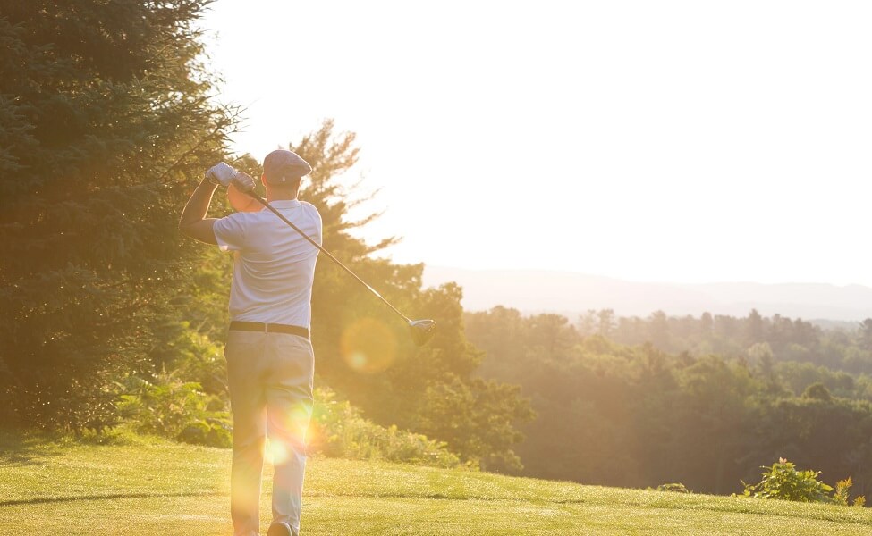 Golfeur sur le parcours de golf du Fairmont Le Château Montebello au coucher du soleil